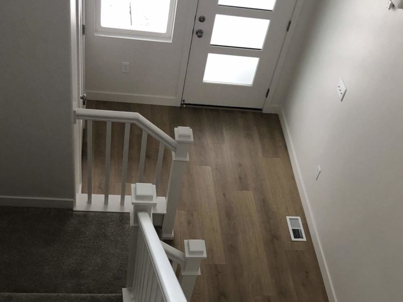Entryway with white staircase and hardwood floors in new rental listing in Heber City, UT