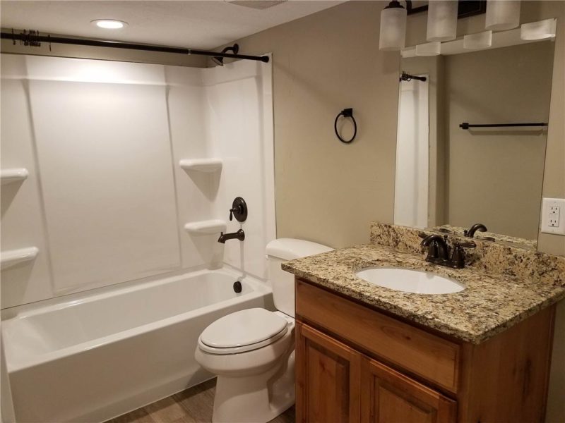 Bathroom interior for new apartment listing in Heber with granite countertop on wood vanity cabinet